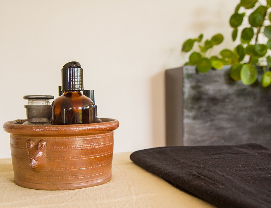 Coupelle en terre cuite avec flacons d'huile de massage